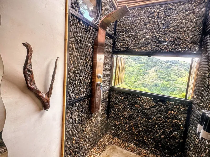 Ducha de agua caliente con ventana panorámica en Bagüe